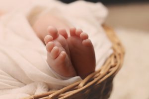 Baby's Feet on Brown Wicker Basket - Wise Options For a Good and Happy Life By Tomer Levi